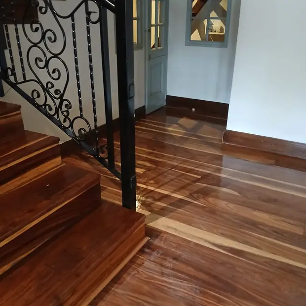 Dark hardwood flooring and timber staircase with wrought-iron balustrade in Bryanston by Impi Teak