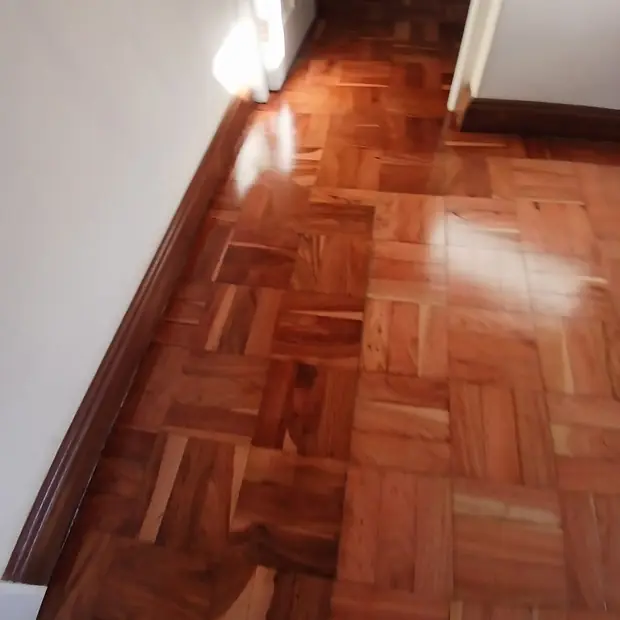 Close detail of parquet wooden flooring meeting a hardwood skirting in Sandton, fitted by Impi Teak