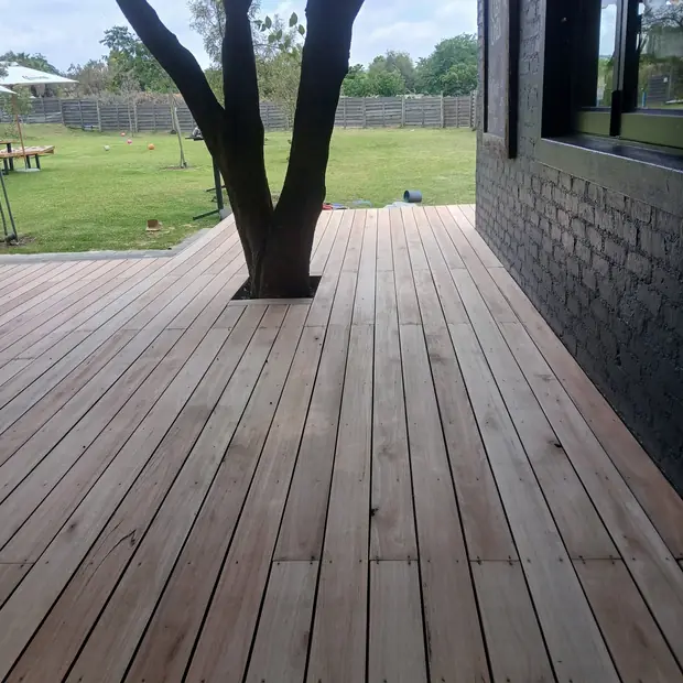Hardwood deck built around a mature tree at a Kyalami property by Impi Teak