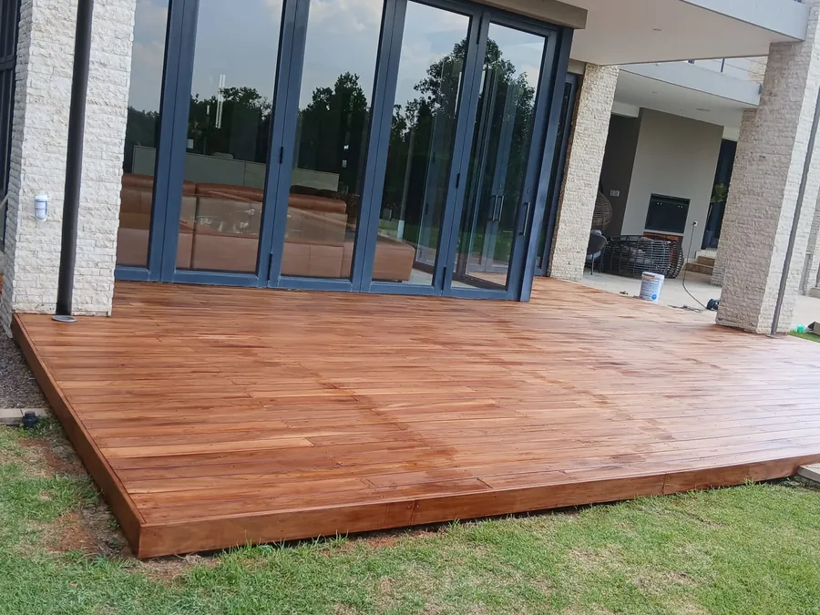 Low hardwood deck platform built out onto a lawn in Gauteng